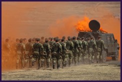 Soldiers running behind military vehicle. with orange smoke screen